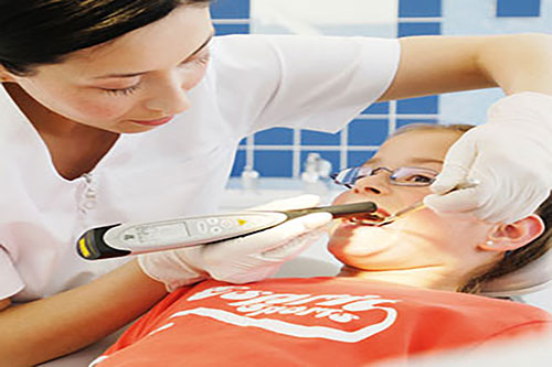 a dental hygienist working on a pediatric patient