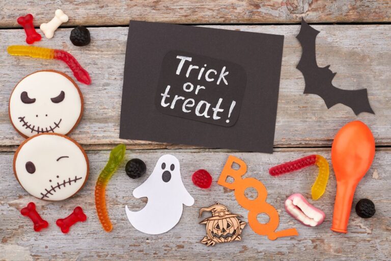 Halloween-themed dental treats and decorations with "Trick treat!" sign on wooden surface.