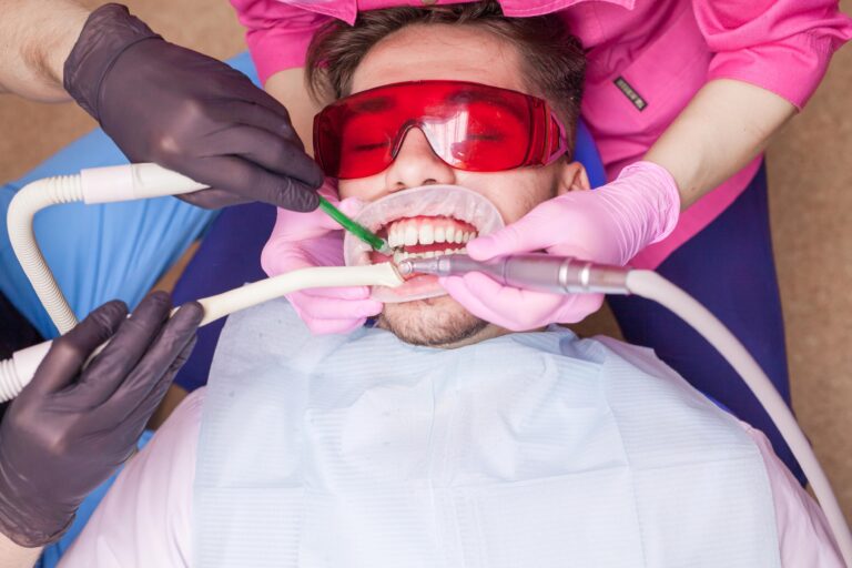 Patient undergoing comfortable sedation dentistry treatment while wearing protective glasses during a dental procedure