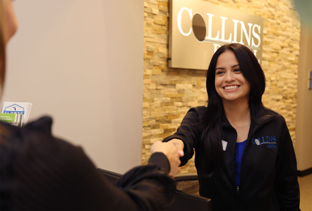 Collins Dental employee shaking the hand of the patient
